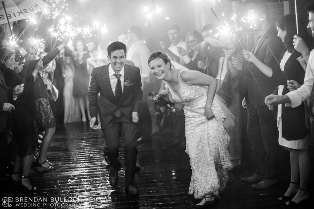 Bride and Groom Walking Between Their Wedding Guests